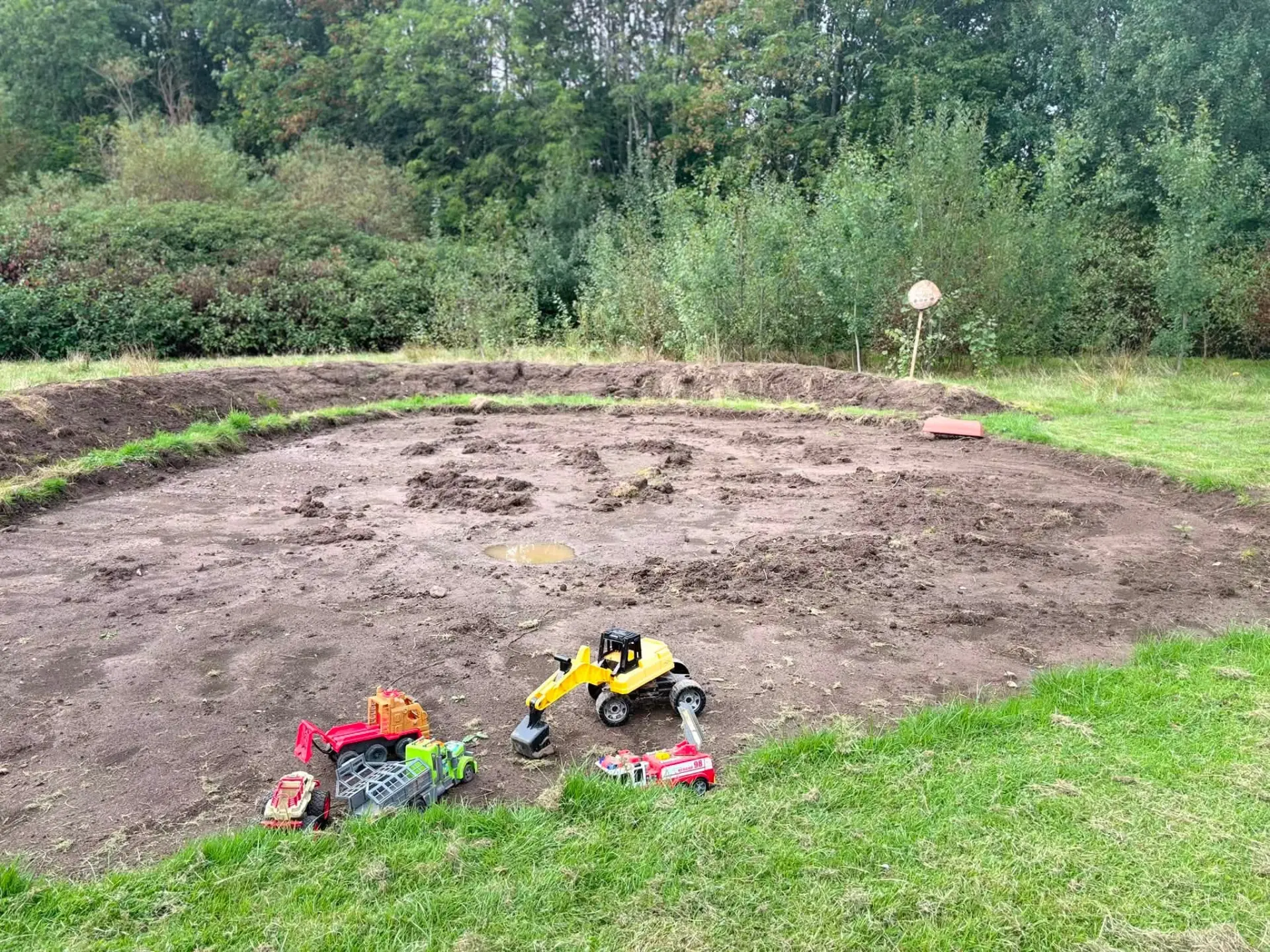 Groundwork underway on the school field with toy diggers on the dug-out play area